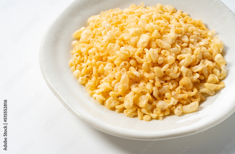 Tenkasu served on a plate placed on a white background. Tenkasu served on a plate placed on a white background.