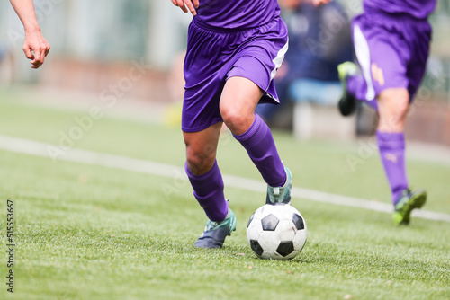 フットボール、サッカーでドリブルする選手の足