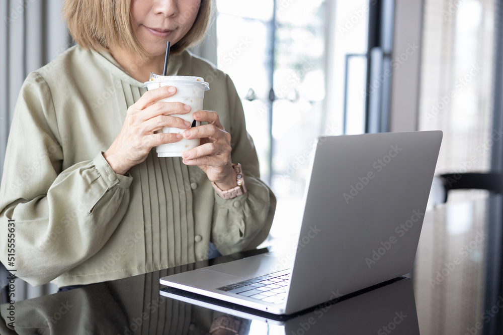 Businesswoman using laptop. young girl working on notebook. female sitting at table drinking ice caramel milk browsing internet. smart modern lifestyle. technology concept. Businesswoman using laptop. young girl working on notebook. female sitting at table drinking ice caramel milk browsing internet. smart modern lifestyle. technology concept.