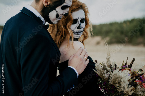 A couple in love is sitting hugging against the backdrop of mountains celebrating Halloween in costu photo