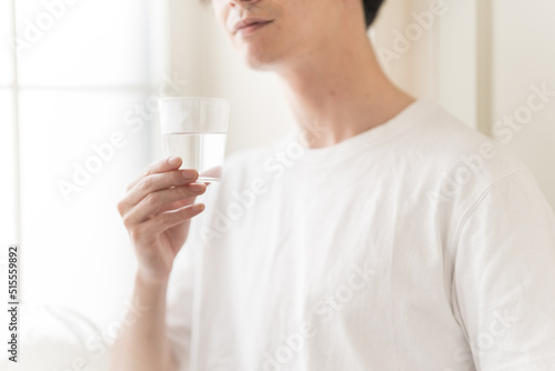 水の入ったグラスを持つ男性 photo