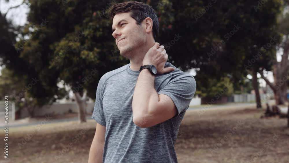 Caucasian man takes a break from his run to rub his neck as it is aching. Caucasian man takes a break from his run to rub his neck as it is aching.