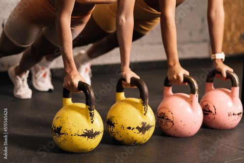 Anonymous female athletes in the exercise of kettlebells effort and self-improvement
