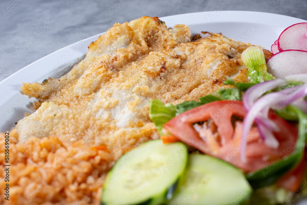A view of a plate of deep fried tilapia filet. A view of a plate of deep fried tilapia filet.