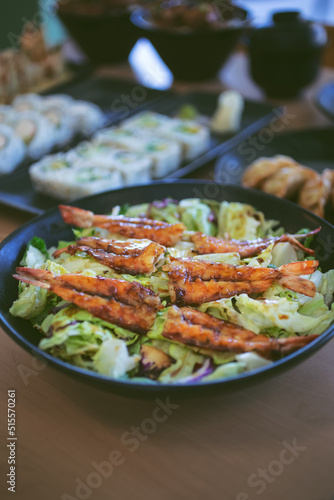A view of a teriyaki shrimp salad bowl, among other Japanese appetizers.