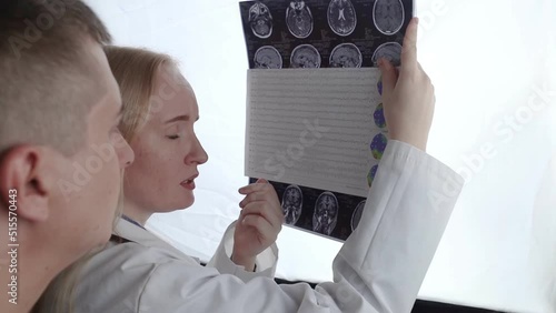 Epileptologist examines patient MRI and electroencephalogram. Concept treating epilepsy and helping people who suffer from this disease. Neurologist at work. Pathology of the brain. Seizure activity