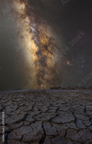 Land with dry and cracked ground and Milky Way galaxy has stars on the background. Desert, Global warming background
