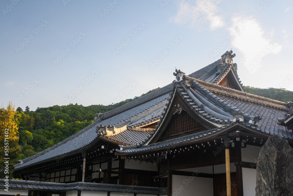 Detail of ancient Japanese traditional roof with clear blue sky background at Tenryu-ji Temple complex in Arashiyama, Kyoto, Japan. No people. 