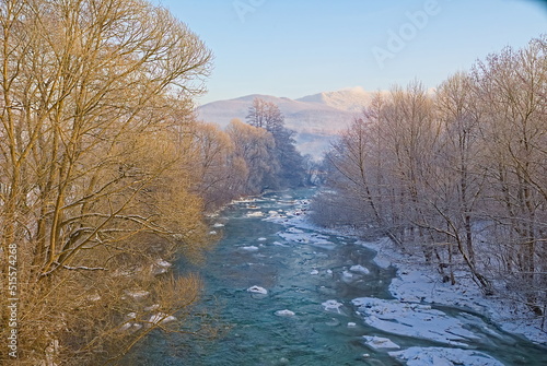 In winter, the unfrozen riverbed in the snow-covered banks. winter background