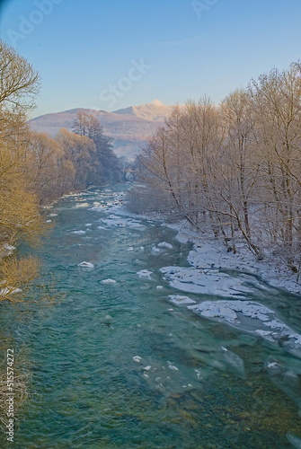 In winter, the unfrozen riverbed in the snow-covered banks. winter background
