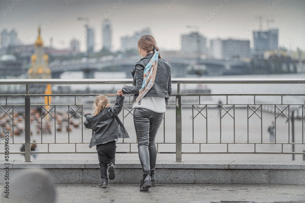 mother plays with her daughter in the city