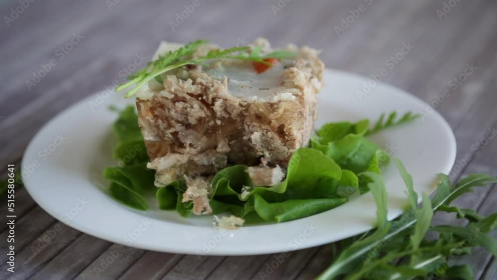 jellied meat with greens and vegetables in a plate on a wooden table jellied meat with greens and vegetables in a plate on a wooden table