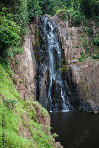 Waterfall called Haew Narok covered by green trees inside tropical rainforest.
