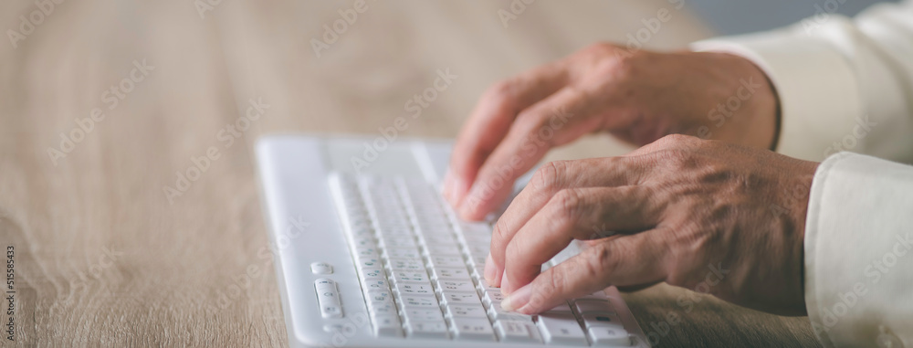 young businessman working on keyboard laying on a wooden table