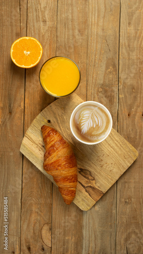 top view of breakfast with Croissant coffee milk and natural orange juice on rustic wood