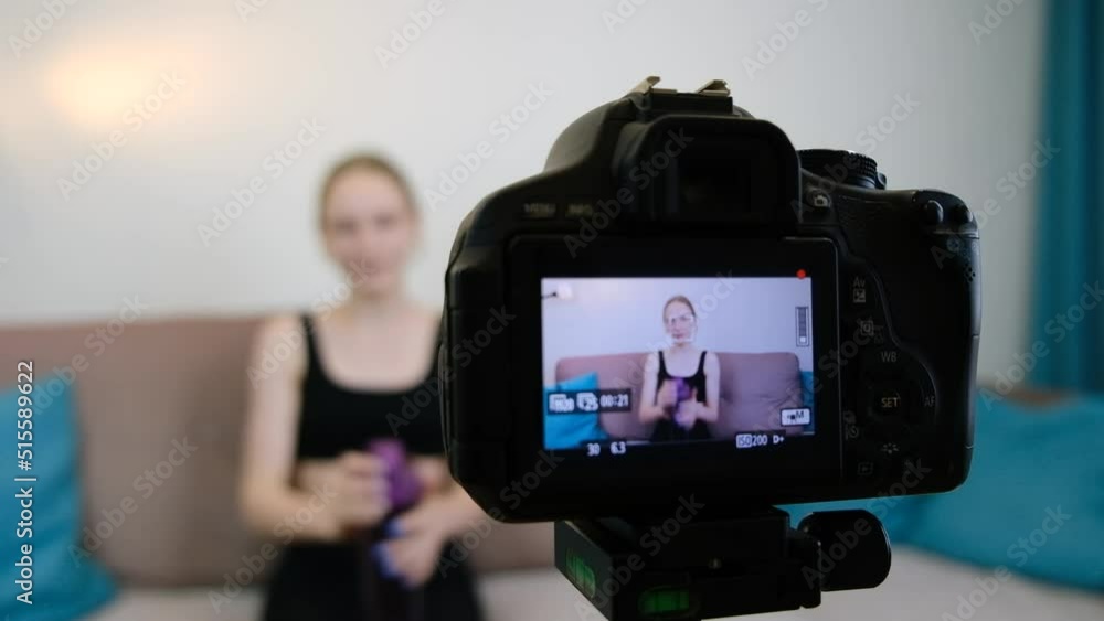 Camera close-up. A fitness blogger talks to the camera about a sports bottle. Blogger records video on camera at home. A young girl communicates on a video camera. Slow motion. Camera close-up. A fitness blogger talks to the camera about a sports bottle. Blogger records video on camera at home. A young girl communicates on a video camera. Slow motion.