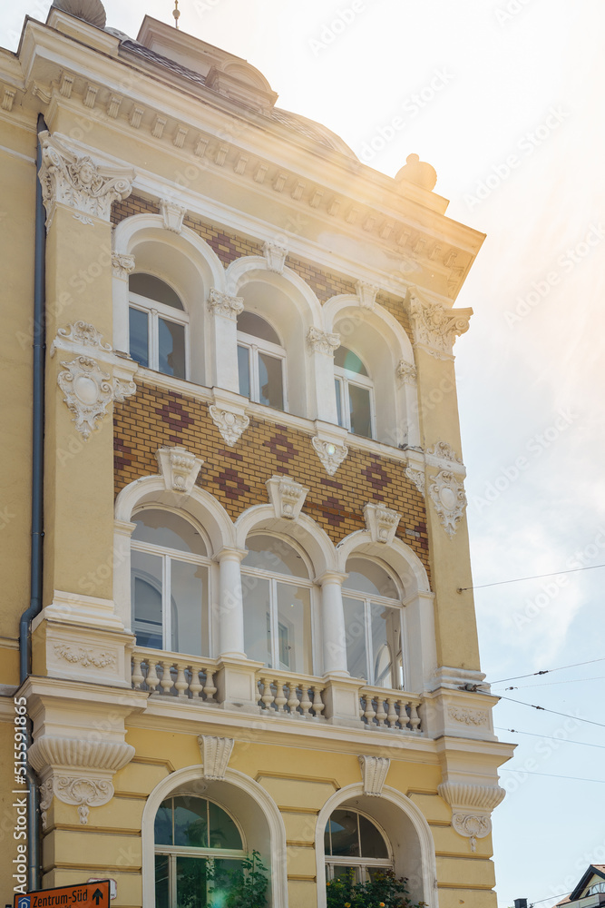 Obraz premium architecture of nineteenth century, an old yellow house with stucco and monograms, in rays of sun. Austria, Baden 