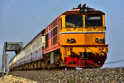 Passenger train by diesel locomotive on the railway in Thailand.