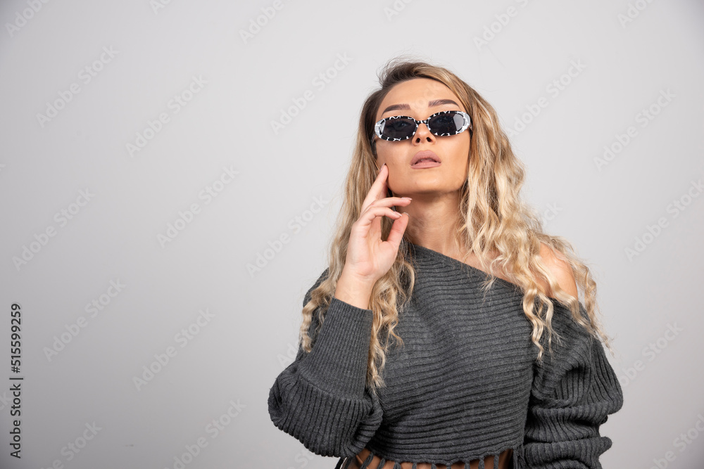 Young woman with eyeglasses standing on gray background Young woman with eyeglasses standing on gray background