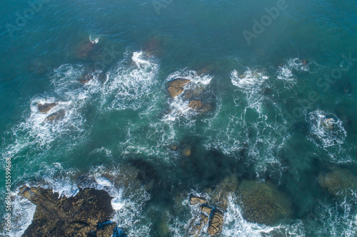 aerial view of waves on coastal rocks