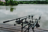 Spinning. Fishing with signaling devices on holder.  Feeder fishing with reel. Rod pod. Fishing rods for pike, perch, carp on pond. Angler with fishing technique. World Fisherman's Day, photo article.