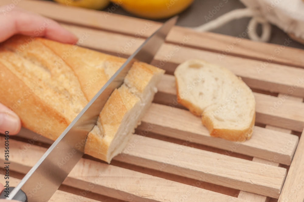 Slicing white bread on a wooden board Slicing white bread on a wooden board
