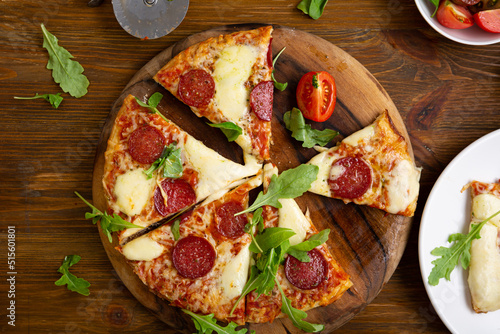 Overhead view of sliced italian salami pizza onplate wood table food