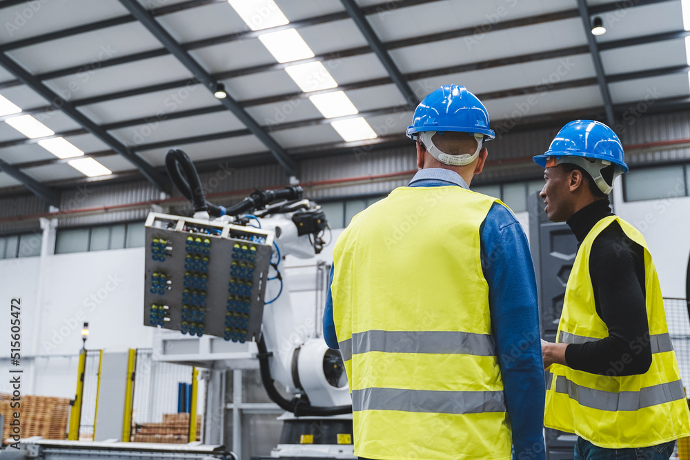 Multiracial engineers working inside automation and robotics facility - New industrial technology concept Multiracial engineers working inside automation and robotics facility - New industrial technology concept