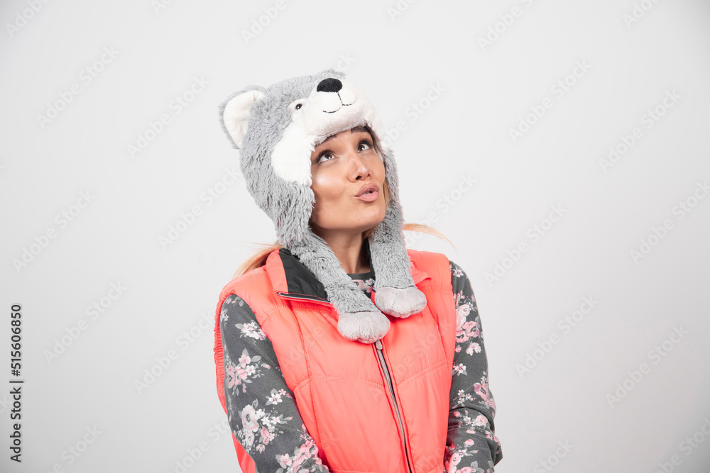 Young woman wearing funny hat on a white wall Young woman wearing funny hat on a white wall