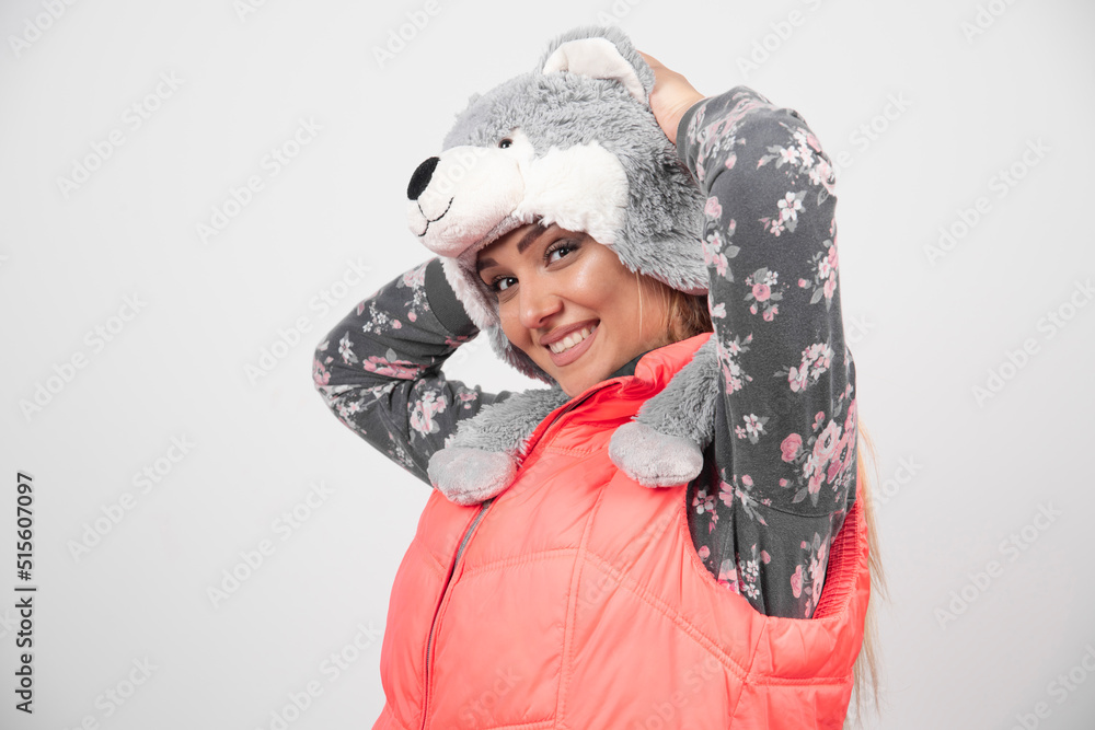 Young woman posing with funny hat on a white wall Young woman posing with funny hat on a white wall