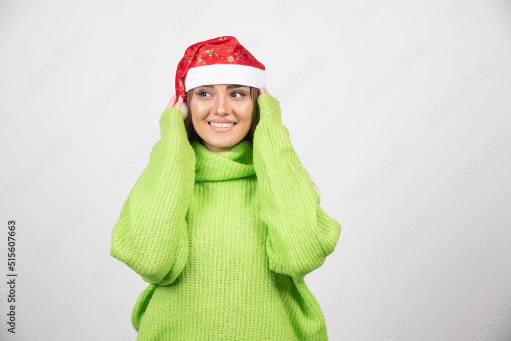 Young pretty woman wearing Santa Claus red hat