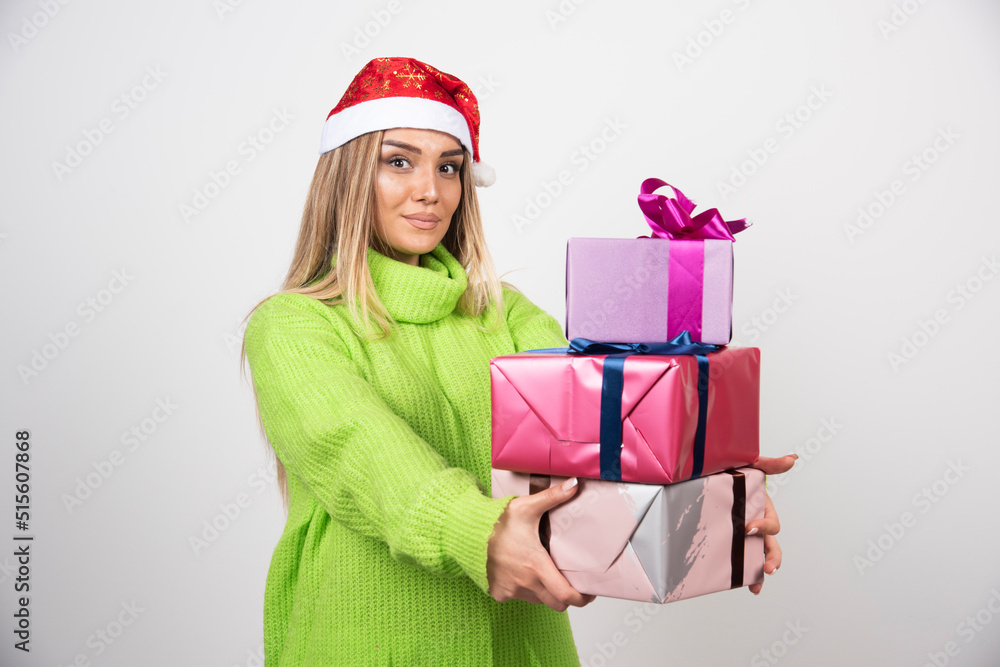Young woman holding a lot of festive Christmas presents Young woman holding a lot of festive Christmas presents