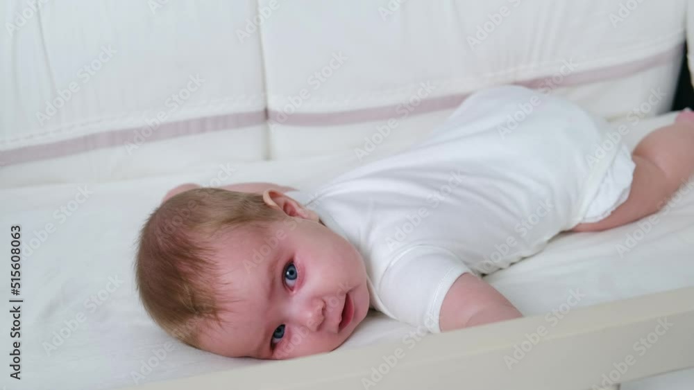 Upset infant baby laying in a bed Upset infant baby laying in a bed