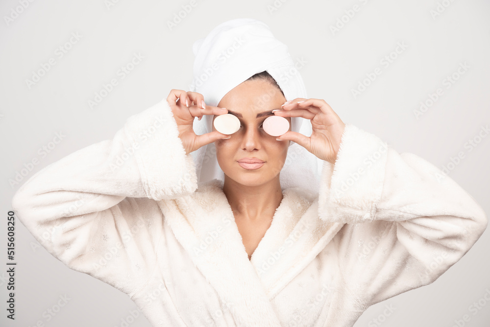 Young woman in a bathrobe doing make-up Young woman in a bathrobe doing make-up