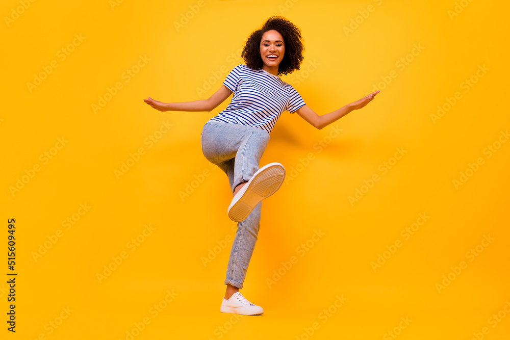 Full body portrait of excited crazy girl raise leg footwear sole dancing isolated on yellow color background Full body portrait of excited crazy girl raise leg footwear sole dancing isolated on yellow color background