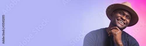 Banner smiling happy american african man wear stylish hat on pink and purple background copy space. Festive and party concept