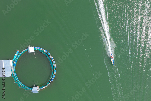 Top view of a small fishing boat passing by a circular fish pen. At Kakiputan Channel in Anda, Pangasinan. photo