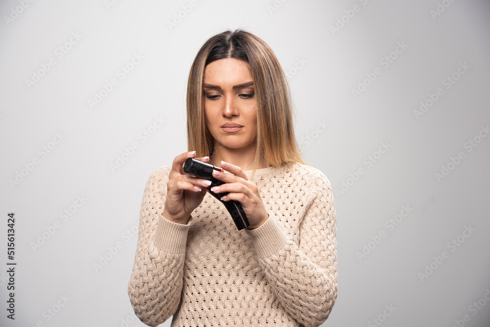 Blonde girl checking photos on polaroid film and feels disappointed Blonde girl checking photos on polaroid film and feels disappointed