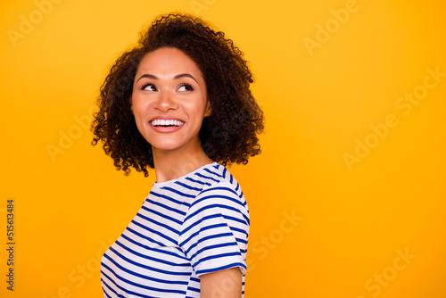 Photo of sweet pretty girl dressed striped t-shirt looking back empty space isolated yellow color background © deagreez