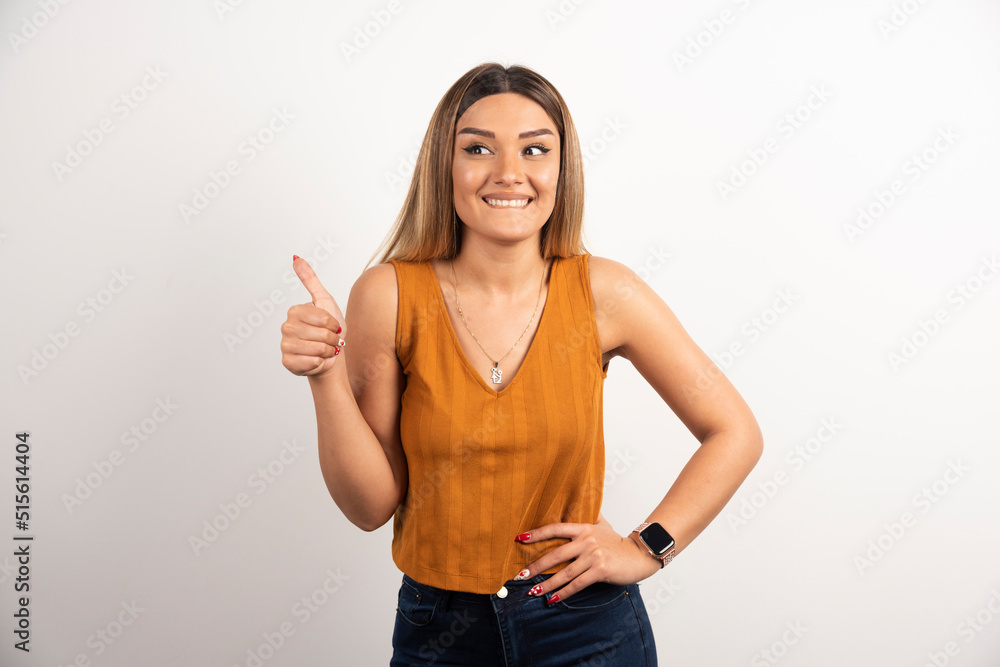 Positive woman showing thumb up and posing on white background Positive woman showing thumb up and posing on white background