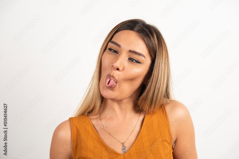 Funny woman showing a tongue on white background Funny woman showing a tongue on white background