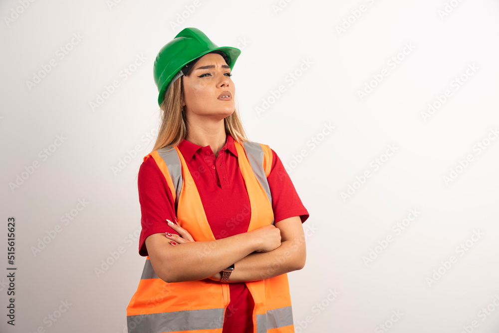 Young construction female worker in green helmet posing on white background Young construction female worker in green helmet posing on white background
