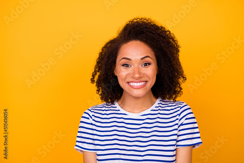 Photo of tricky funky girl dressed striped t-shirt smiling empty space isolated yellow color background