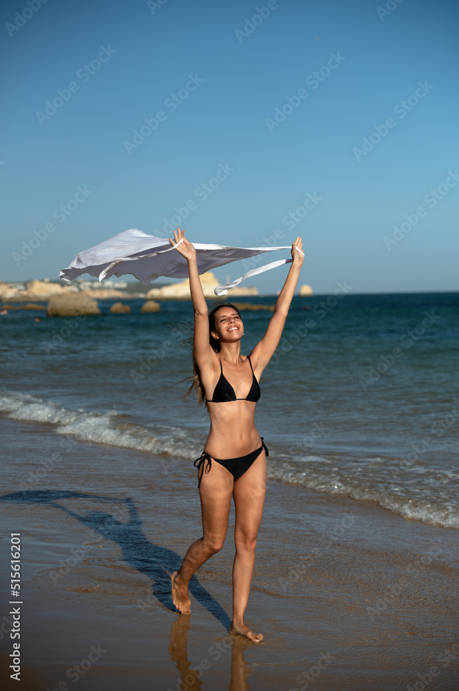 Happy woman with garment on shore