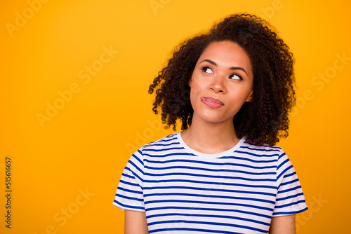 Portrait of minded adorable girl tongue lick lip look interested empty space isolated on yellow color background © deagreez