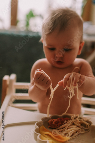 Cute baby eating spaghetti photo