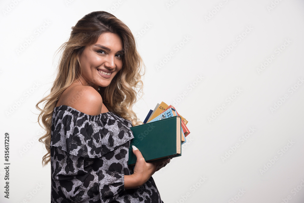 Young woman holding books while laughing on white background Young woman holding books while laughing on white background