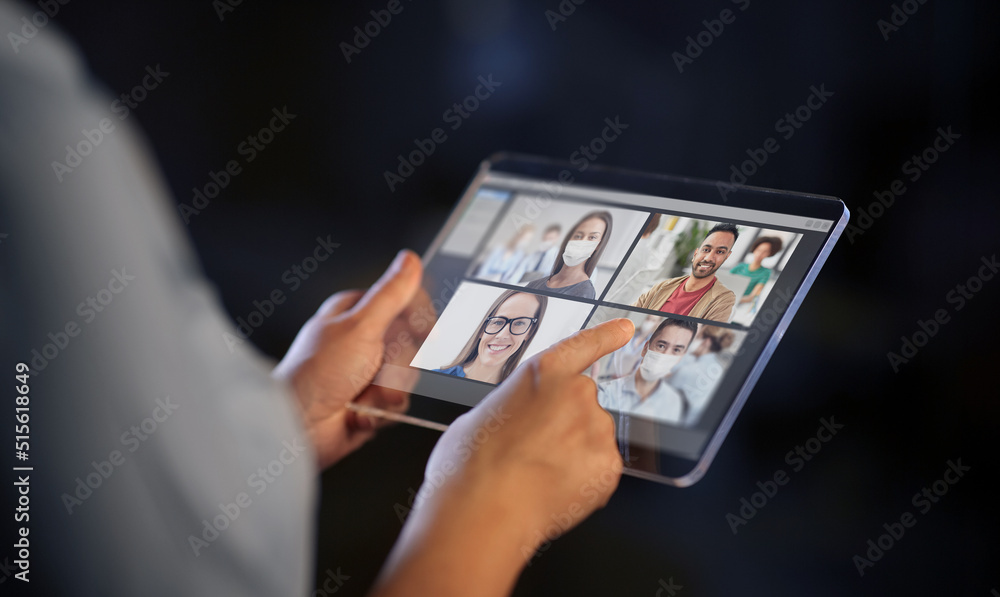 business, communication and technology concept - close up of hands with transparent tablet pc computer having video conference with group of people, colleagues or friends on black background business, communication and technology concept - close up of hands with transparent tablet pc computer having video conference with group of people, colleagues or friends on black background