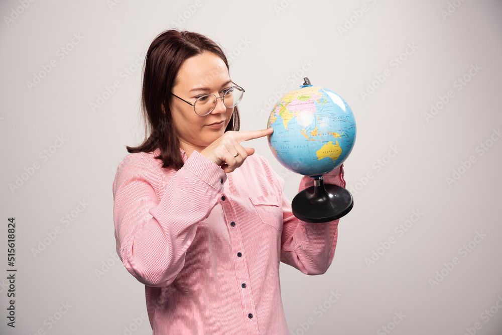 Portrait of woman looking on an Earth globe on a white background Portrait of woman looking on an Earth globe on a white background