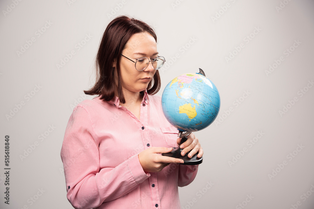 Portrait of woman looking on an Earth globe on a white background Portrait of woman looking on an Earth globe on a white background